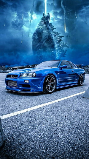 Blue Nissan Skyline GT-R R34 with Godzilla Roaring in Background HD phone wallpaper