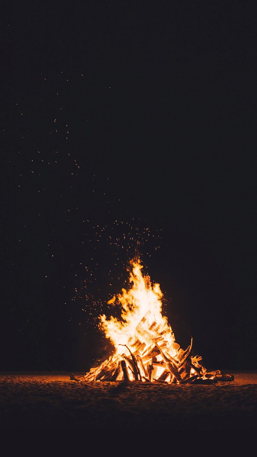 Bonfire Burning Brightly at Night with Sparks Flying into the Dark Sky HD phone wallpaper