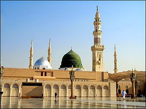 Al-Masjid an-Nabawi in Medina featuring the iconic Green Dome and towering minarets under a clear blue sky HD wallpaper