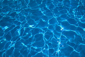 Cascading Blue Water Surface with Sunlight Reflections and Ripples HD wallpaper