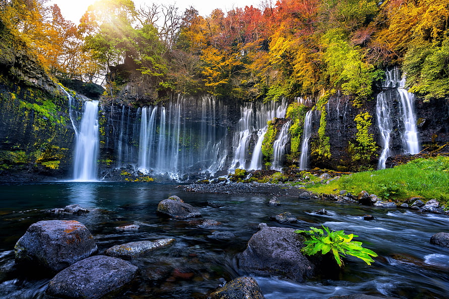 Stunning Autumn Waterfall Cascading Over Mossy Rocks Into a Serene Forest Stream HD wallpaper