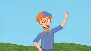 Blippi Waving in a Blue Shirt and Orange Beret on a Green Hill HD wallpaper