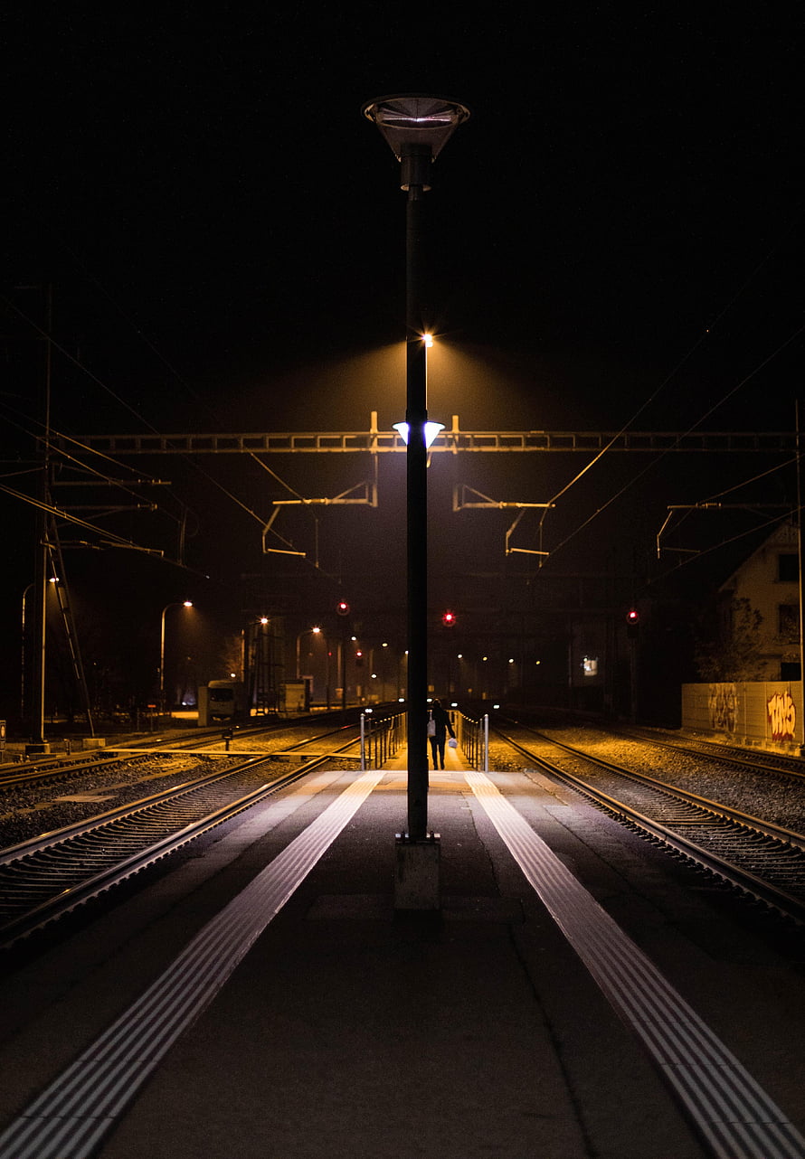 Illuminated Railway Platform at Night with Overhead Catenary Wires and Distant Signals HD phone wallpaper