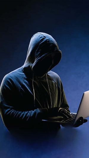 Anonymous Hacker in Hoodie Typing on Laptop in Dark Blue Room HD phone wallpaper