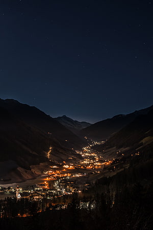 Night View of a Glowing Mountain Village Under a Starry Sky HD phone wallpaper