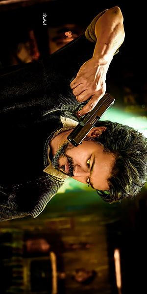 Thalapathy Vijay in a dramatic action pose holding a pistol from the movie Beast HD phone wallpaper