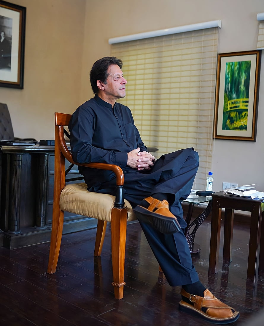 Imran Khan Sitting in a Chair Wearing Traditional Black Shalwar Kameez and Brown Sandals HD phone wallpaper