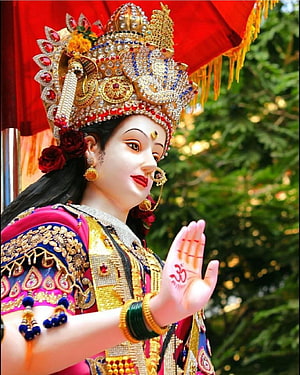 Ornate Goddess Statue with Golden Crown and Abhaya Mudra Hand Gesture HD phone wallpaper