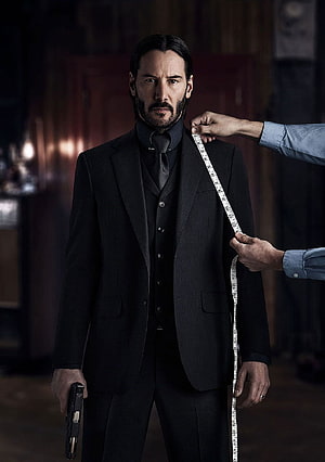 Keanu Reeves as John Wick in a black suit holding a gun during a tailoring scene HD phone wallpaper