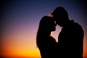 Romantic Couple Silhouette Against Vibrant Sunset Sky HD wallpaper
