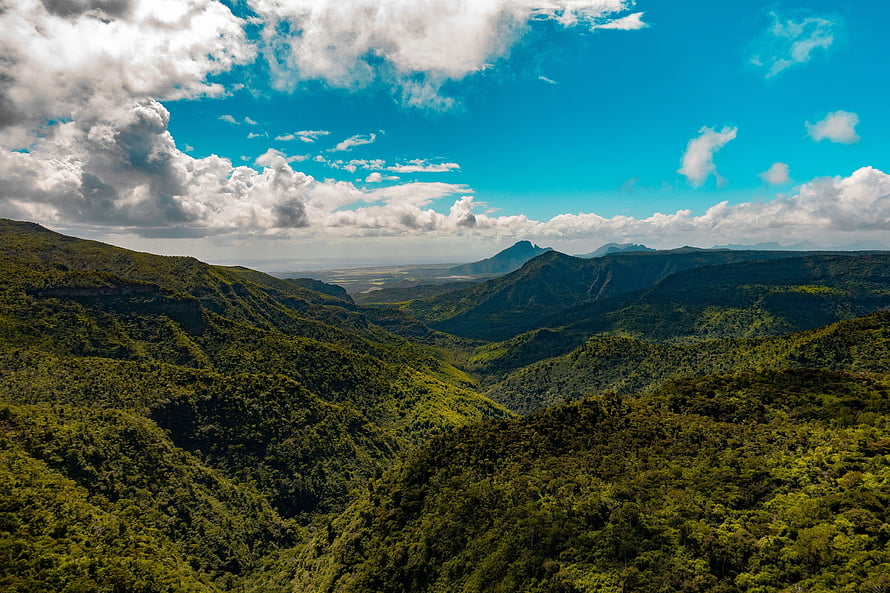 Lush Green Mountain Ranges Under a Bright Blue Sky with Scattered Clouds HD wallpaper