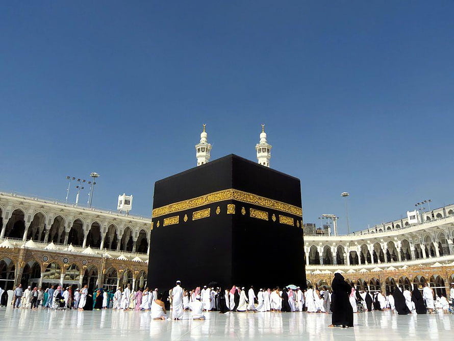 The Kaaba in Mecca with pilgrims performing Tawaf under a clear blue sky HD wallpaper