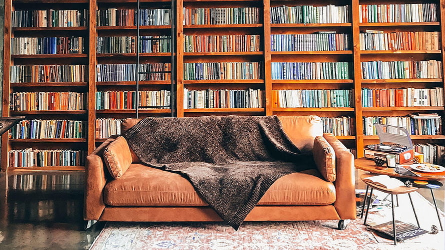 Cozy Library Living Room with Leather Sofa and Bookshelves HD wallpaper