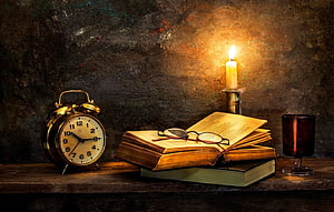 Vintage Study Scene With Antique Clock, Open Books, Glasses, And Lit Candle HD wallpaper