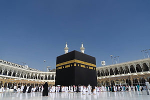 The Kaaba in Mecca Surrounded by Pilgrims Under a Clear Blue Sky HD wallpaper
