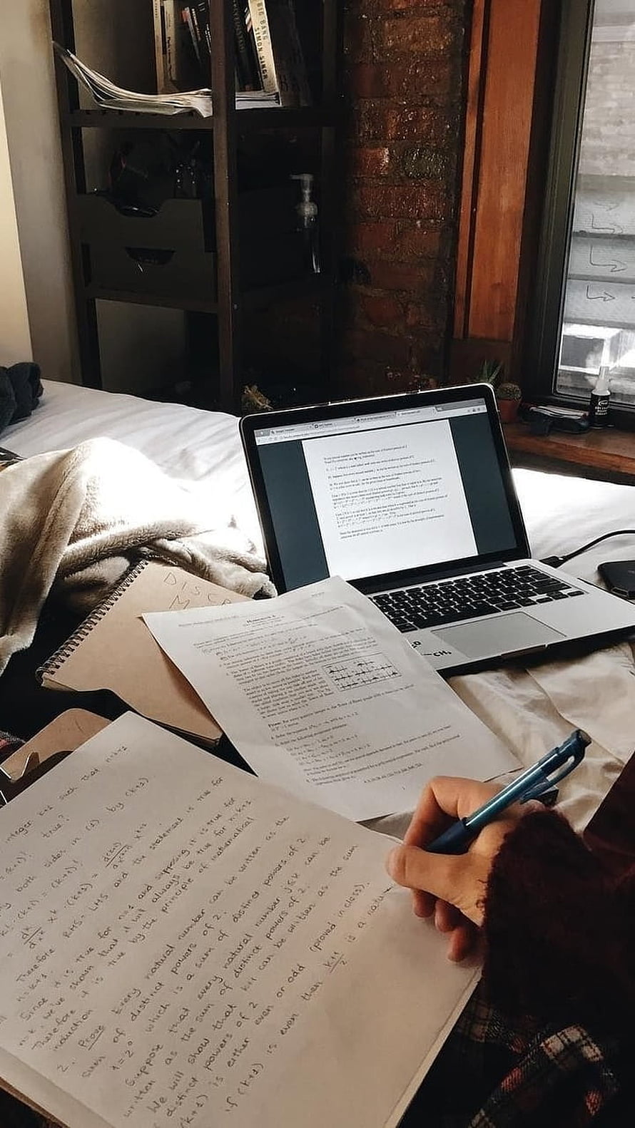 Cozy study session on bed with laptop and handwritten math notes HD phone wallpaper