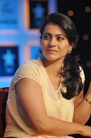Kajol Devgan in a cream blouse with gold earrings at a stage event HD phone wallpaper