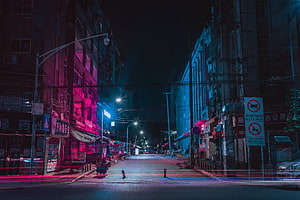 Neon-lit urban street at night with vibrant pink and blue lighting HD wallpaper