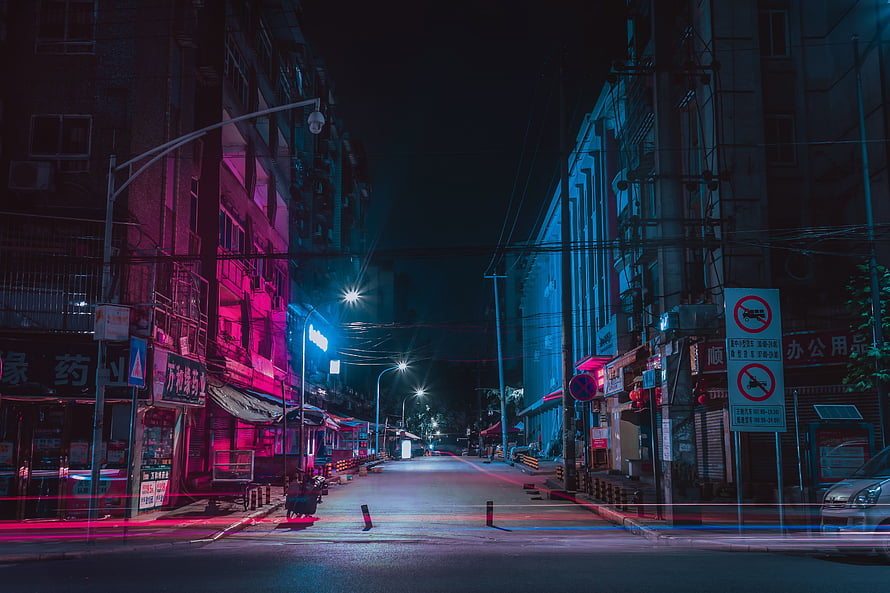 Neon-lit urban street at night with vibrant pink and blue lighting HD wallpaper