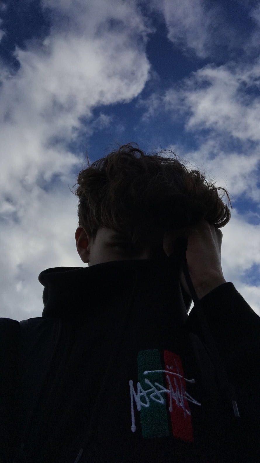Moody Low-Angle Portrait of a Young Man in a Black Hoodie Against a Cloudy Blue Sky, YahItsMe. graphy poses for men, Boy graphy poses, Cute teenage boys, Teenage Boy Aesthetic HD phone wallpaper