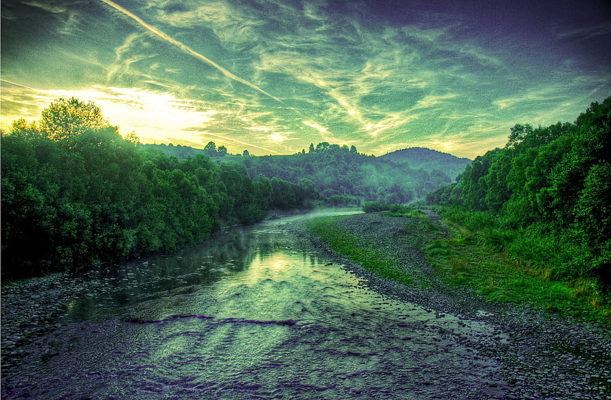 Serene River Landscape with Lush Green Forests and Dramatic Sky HD wallpaper