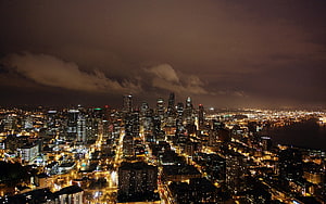 Aerial Night View of a Glowing Metropolitan Skyline with Dense Urban Grid and Waterfront HD wallpaper