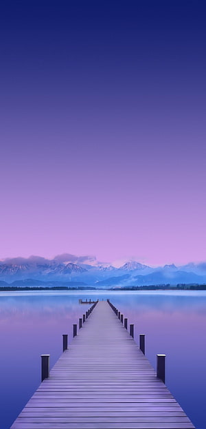 Serene Wooden Pier Extending Into Calm Lake With Distant Snow-Capped Mountains Under a Soft Purple Twilight Sky HD phone wallpaper