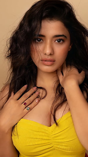 Portrait of a woman with wavy dark hair wearing a yellow top and rings, Kethika sharma, telugu actress HD phone wallpaper