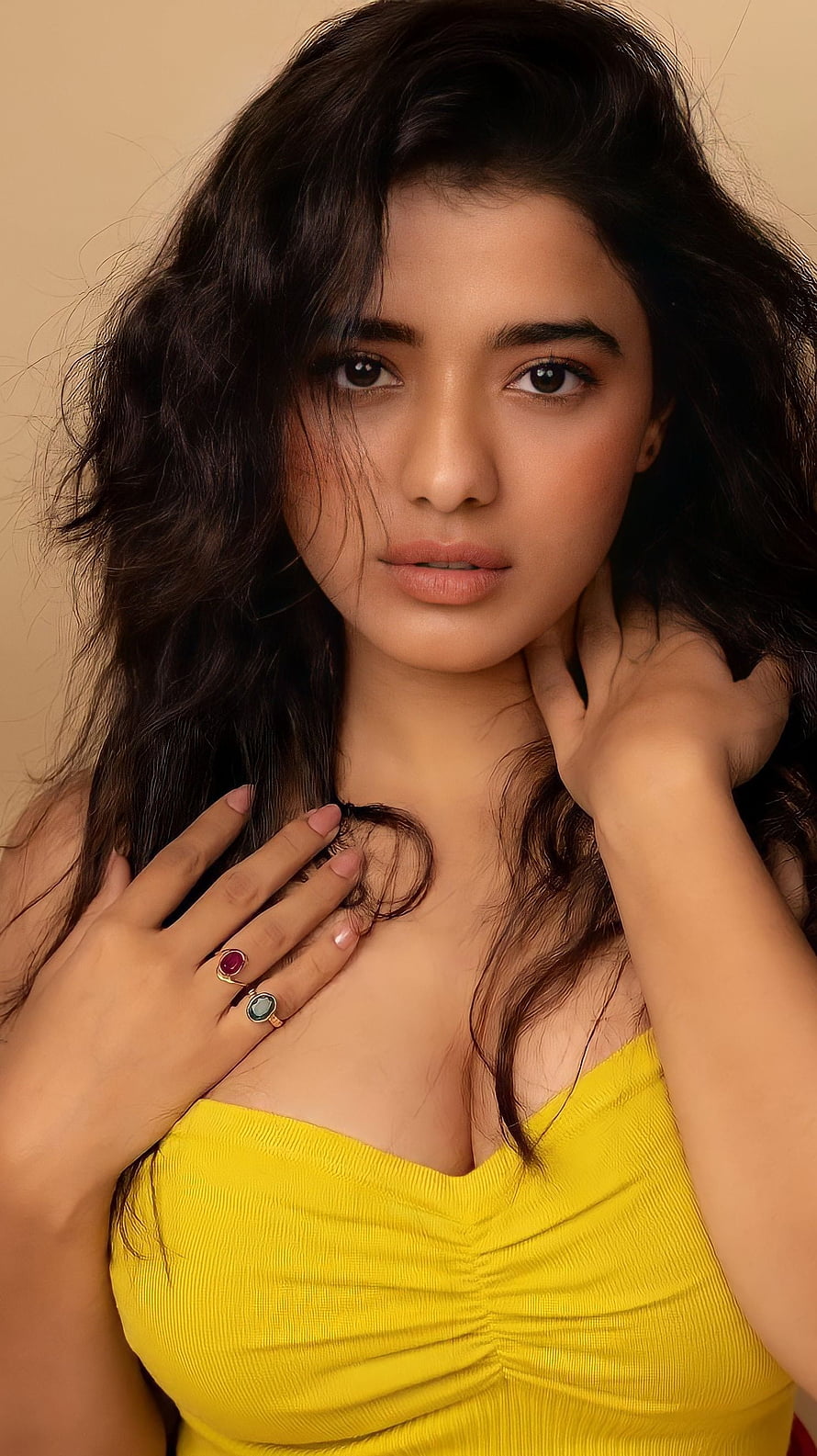 Portrait of a woman with wavy dark hair wearing a yellow top and rings, Kethika sharma, telugu actress HD phone wallpaper