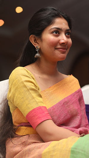 Portrait of a woman wearing a vibrant yellow and pink saree with traditional jhumka earrings, Sai Pallavi, saree lover, tamil actress HD phone wallpaper