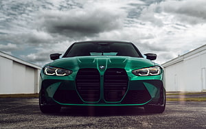 Front View of a Green BMW M3 G80 Sedan Parked on an Airfield Tarmac Under a Cloudy Sky HD wallpaper