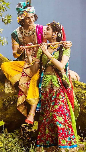 Radha and Krishna Playing Flute Together in Traditional Attire HD phone wallpaper