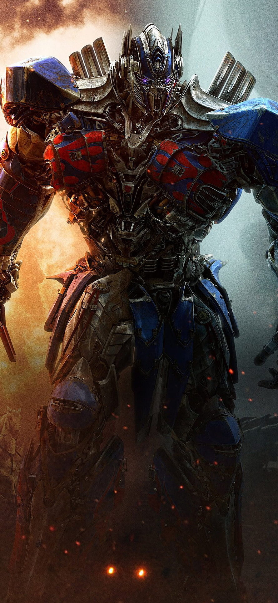 Optimus Prime battle-ready robot standing in a fiery battlefield with glowing embers and dramatic lighting HD phone wallpaper