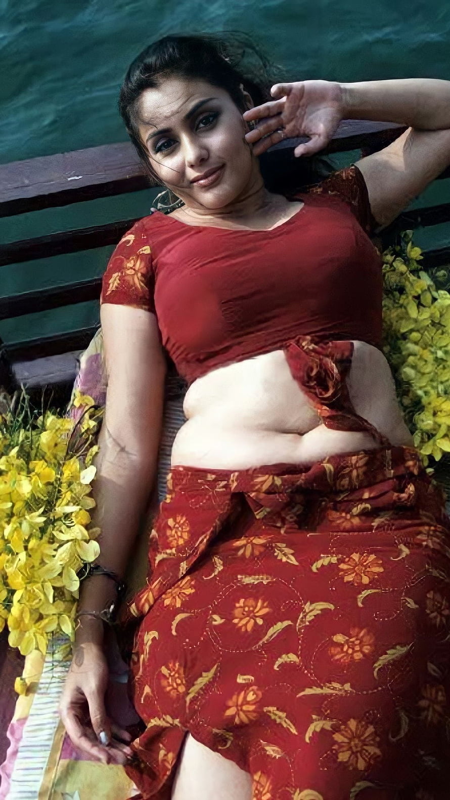 Namitha Kapoor in a Red Floral Saree Lying on a Bench with Yellow Flowers HD phone wallpaper