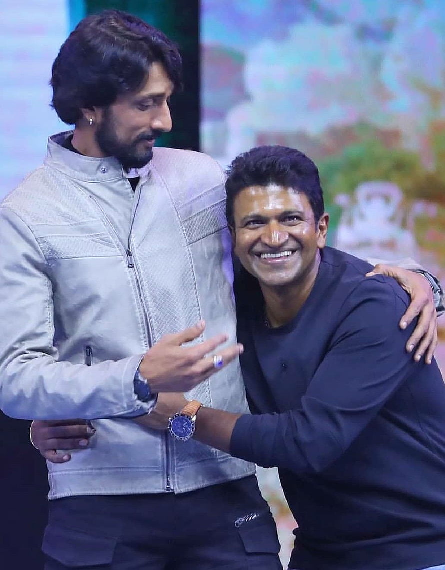 Sudeep and Puneeth Rajkumar Embracing at a Film Industry Event HD phone wallpaper