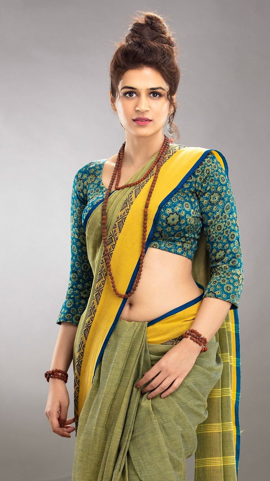 Indian actress in a green and yellow saree with a blue patterned blouse and rudraksha beads HD phone wallpaper