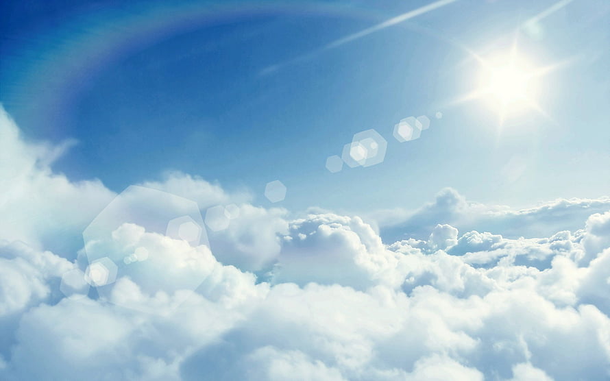 Bright Sunlight Breaking Through Fluffy White Clouds in a Clear Blue Sky HD wallpaper