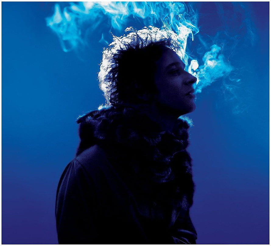 Gustavo Cerati in dramatic blue profile with swirling smoke and fur collar HD wallpaper