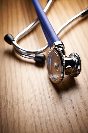 Blue Stethoscope Resting on a Warm Wooden Surface Close-Up HD phone wallpaper