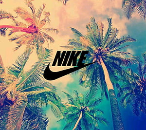 Nike Logo Over Tropical Palm Trees Against a Warm Sunset Sky HD wallpaper