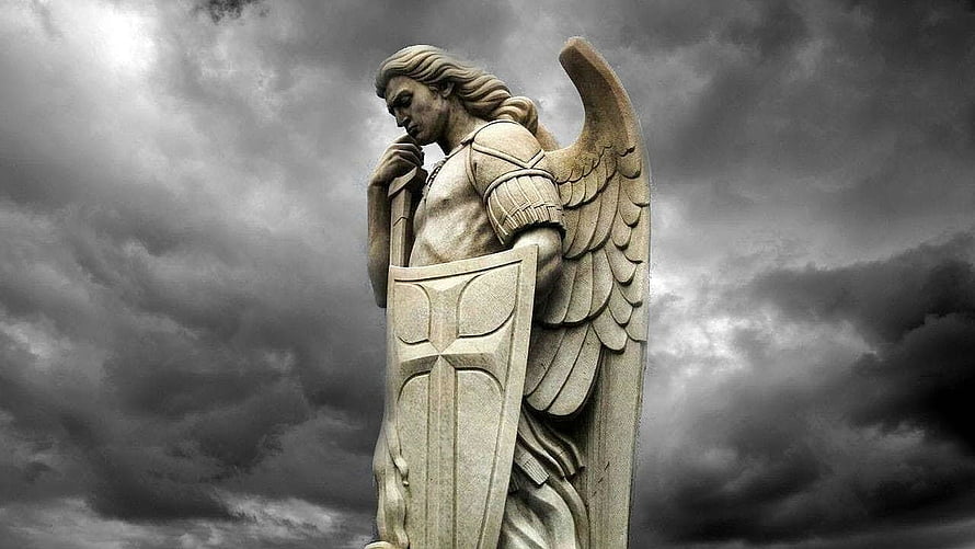 St. Michael the Archangel Statue with Shield and Wings Against Dramatic Stormy Sky HD wallpaper