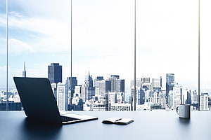 Modern Office Desk With Laptop And Coffee Overlooking City Skyline HD wallpaper