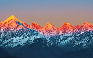 Golden Sunrise Illuminating Snow-Capped Mountain Peaks at Dawn HD wallpaper