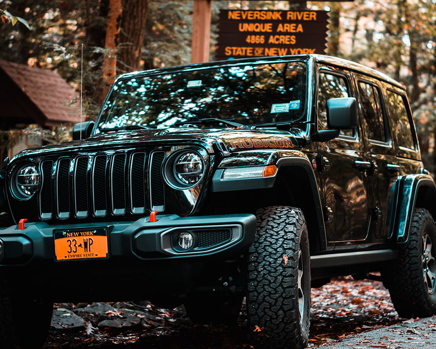 Black Jeep Wrangler Rubicon parked in a forest with New York license plate HD wallpaper