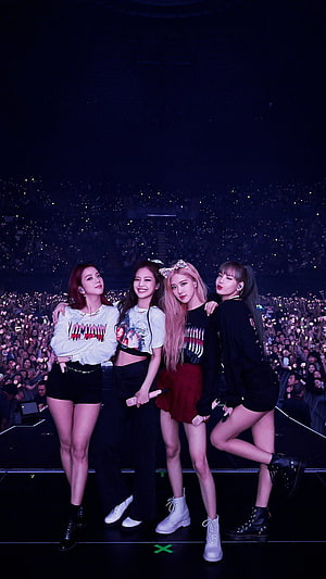 Blackpink concert stage photo with Jennie, Lisa, Rosé, and Jisoo posing together in front of a massive crowd with lightsticks HD phone wallpaper