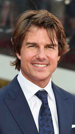 Tom Cruise in a navy suit and patterned tie at a formal event HD phone wallpaper