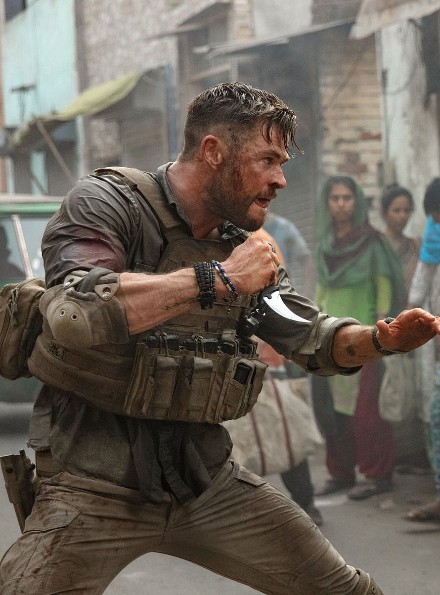 Chris Hemsworth in tactical gear during an intense action scene in the film Extraction HD phone wallpaper