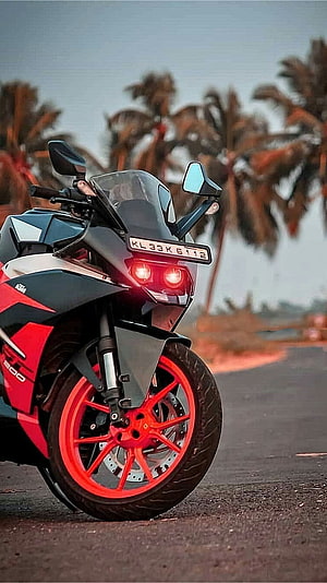 KTM RC 390 Sport Motorcycle with Red Wheels Parked on a Road Near Palm Trees HD phone wallpaper