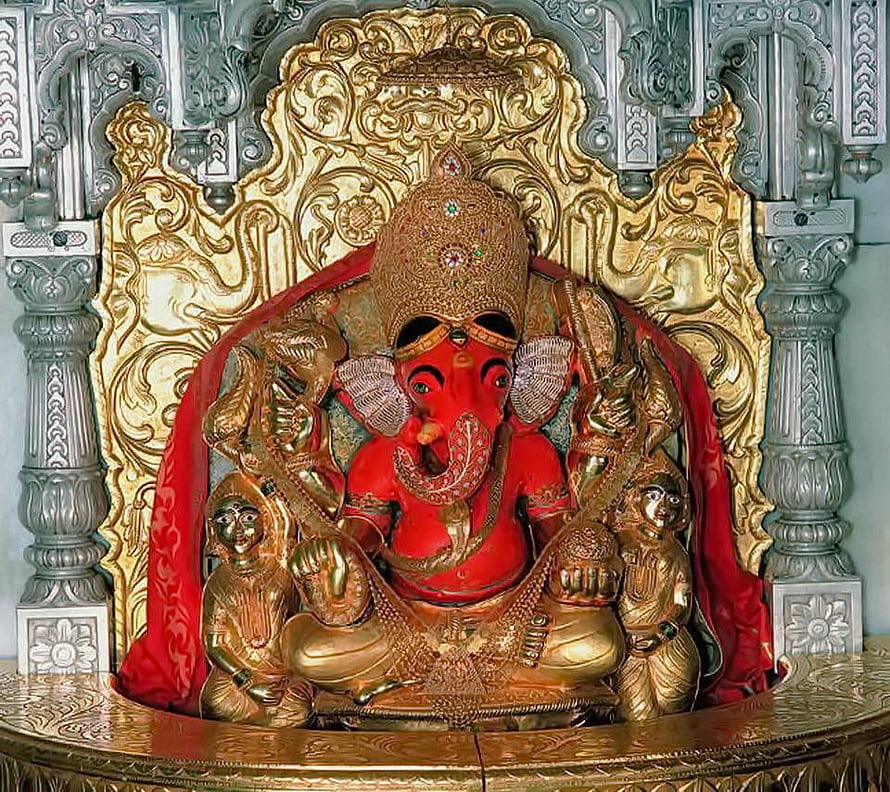 Red Ganesha Statue with Golden Crown and Ornate Temple Shrine Background HD wallpaper