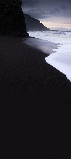 Dramatic Black Sand Beach with Crashing Waves and Dark Cliffs at Dusk HD phone wallpaper